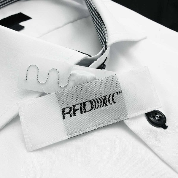 A White shirt with RFID UHF transponder for handling of garments. Collected from ACG Pulse high-quality digitalized logistics systems. Garment handling systems with RFID to save money, space and time.
